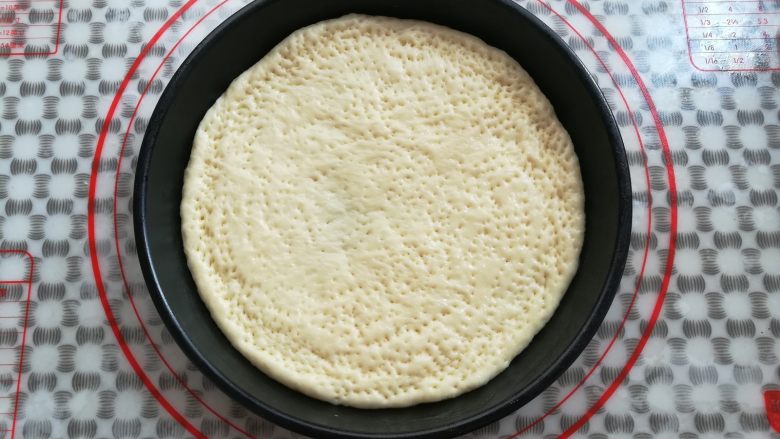 缤纷水果披萨,把面团放入抹了油的披萨盘中,在面团上用叉子戳出小洞
