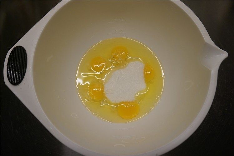 南瓜仁全蛋海绵蛋糕,盆里放进全蛋,一次性加进砂糖、水怡手动打蛋器搅匀打散