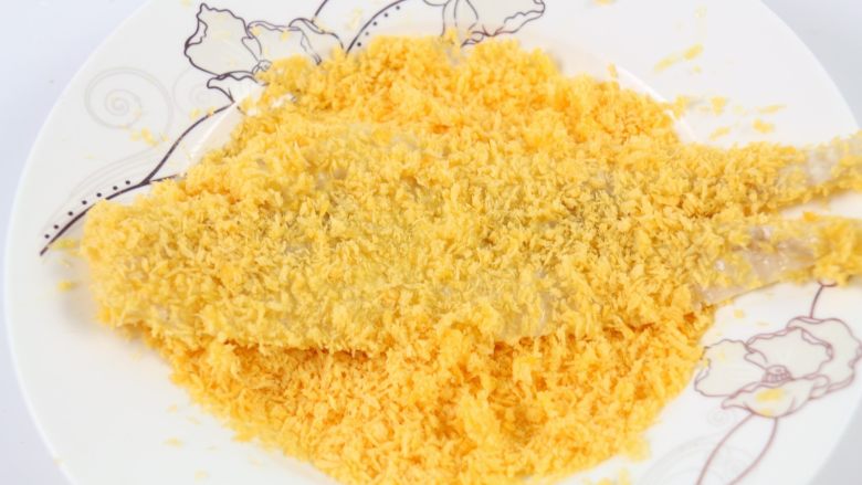 香煎鲽鱼片,最后放在面包糠上,每一个位置都沾上面包糠,用手指适当的摁压一下。