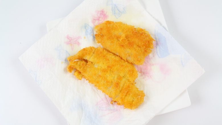香煎鲽鱼片,待两面都煎得金黄后,即可起锅,放在厨房纸上,吸去多余的油。
