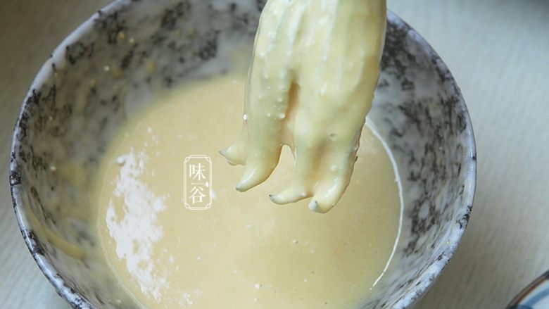 酥炸南瓜花,再放入面粉糊里面裹上一层面糊,裹好后拿起静止一下滴去多余的面糊;