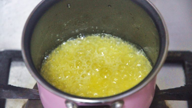 费南雪,黄油中小火加热,慢慢熬到茶色后关火,过滤黄油中的杂质。