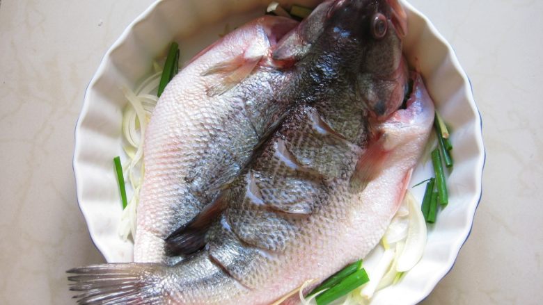川香麻辣烤鱼:麻辣过瘾的豪华烤鱼,将腌好的鱼放入烤盘中。
