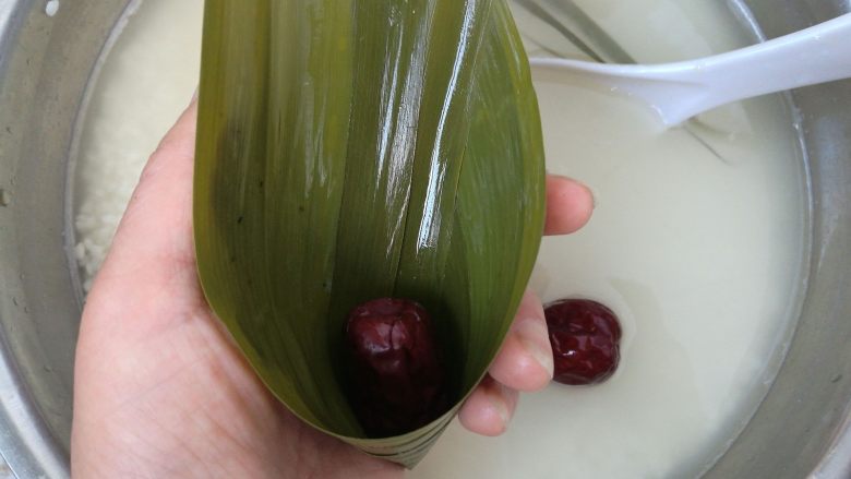 大红枣粽子,粽叶折成一个漏斗的形状,放进一颗大枣。