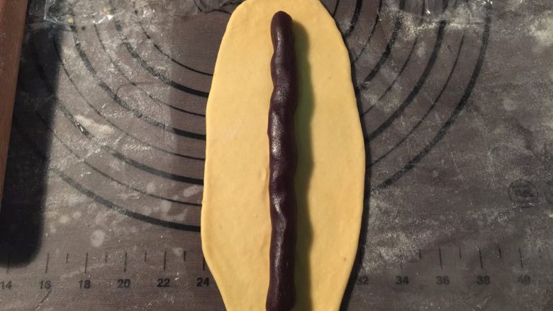 豆沙红薯面包,取一个小团擀成长条状,放入适量豆沙卷起来,如此反复
