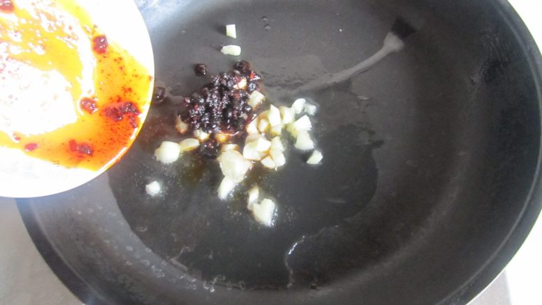 肉末干子炒毛豆米,热锅凉油, 放入蒜末和豆豉酱爆香;