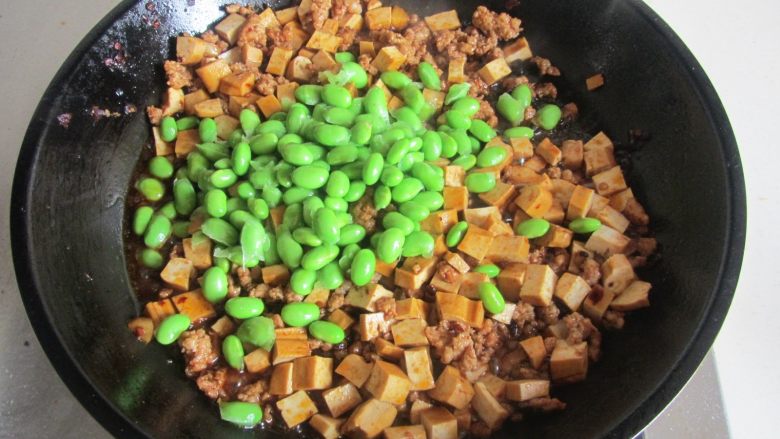 肉末干子炒毛豆米,下入毛豆米进去翻炒;