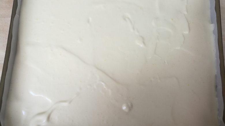 草莓蛋糕卷,用刮板刮平。轻震烤盘,震出大气泡。