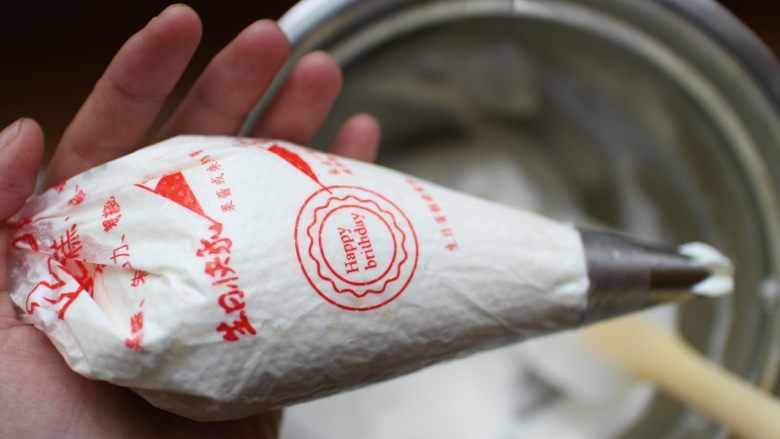 芒果盒子蛋糕,将打发好的淡奶油装进裱花袋。我的裱花袋装了花嘴,没有的同学可以不用装裱花嘴!