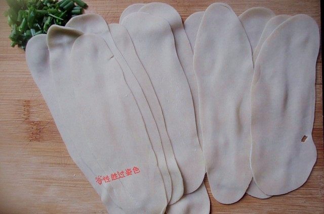 饺子皮变身油泼面,两拇指边轻轻往两头揉搓边抻扯,直至把饺子片抻扯成薄薄的长条