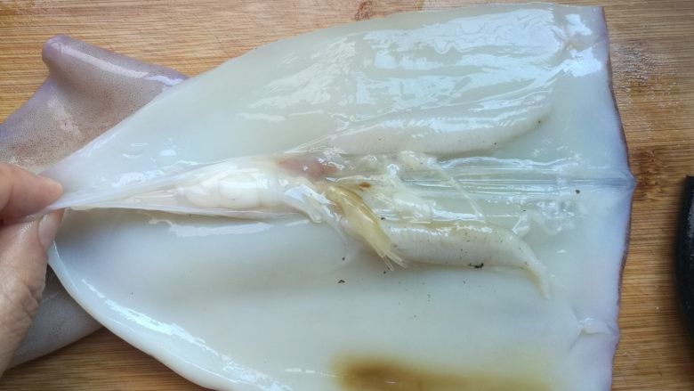 双椒爆鱿鱼,清理鱿鱼身,须留作他用。中间剪开,取出软骨,彻底清理干净。