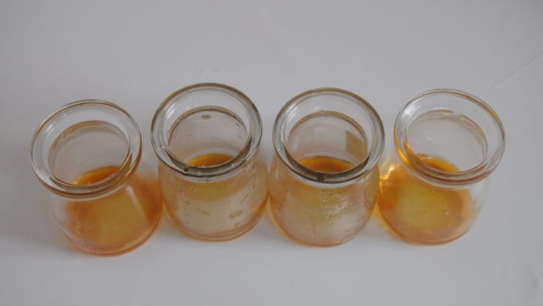 草莓加州葡萄干布丁,20克细砂糖和50克清水小火慢煮至琥珀色,取出倒入准备好的小玻璃瓶底部