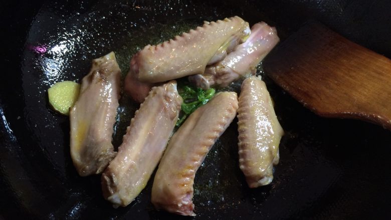 可乐鸭翅膀,放入鸭翅,煸炒至肉变色。