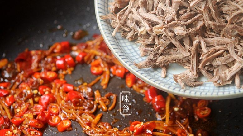 麻辣手撕牛肉,倒入撕好的牛肉下去翻炒至牛肉丝全部裹上酱料,变成深红色为止;