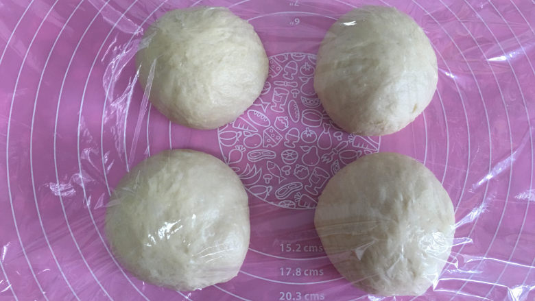 焦糖核桃小吐司,发酵完成取出面团进行排气,排气后将面团平均分成四份,滚圆后醒面15分钟。