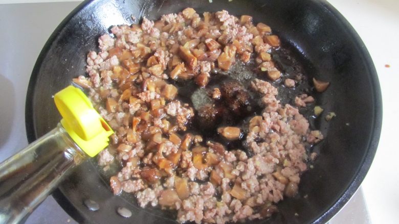 香菇肉末面, 翻炒几下后再倒入适量的味极鲜翻炒上色;