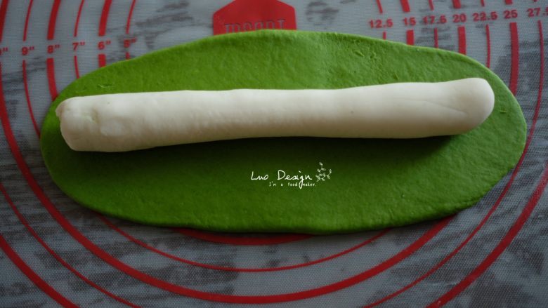 翡翠白玉饺子,绿面团擀成长舌形状,
白面团搓成长条形状,
然后像图中这样摆好,
绿面团把白面团包裹起来,捏紧。