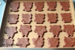 小熊猫饼干,小心移到不沾烤盘上,第一遍压完后可以重新揉好可可面团再次擀开反复操作一遍,直至把面团都摆好在不沾烤盘上