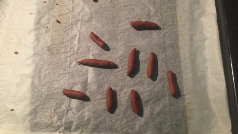 南瓜形豆沙包,在面团发酵时,用可可面团搓成细条,切成小段放入烤箱170度烤8分钟