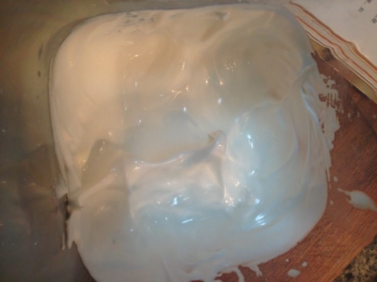 轻乳酪蛋糕,第三步:打到蛋白表面开始出现纹路,倒入剩下的1/3细砂糖。直至打发到接近硬性发泡的程度。(提起打蛋器后,拉出一个尖尖的角,角的顶端有稍微的弯曲。)