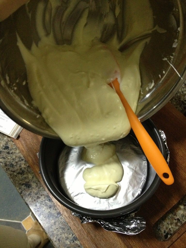 轻乳酪蛋糕,把蛋糕糊倒入蛋糕模里。然后震下蛋糕模,震出大气泡。