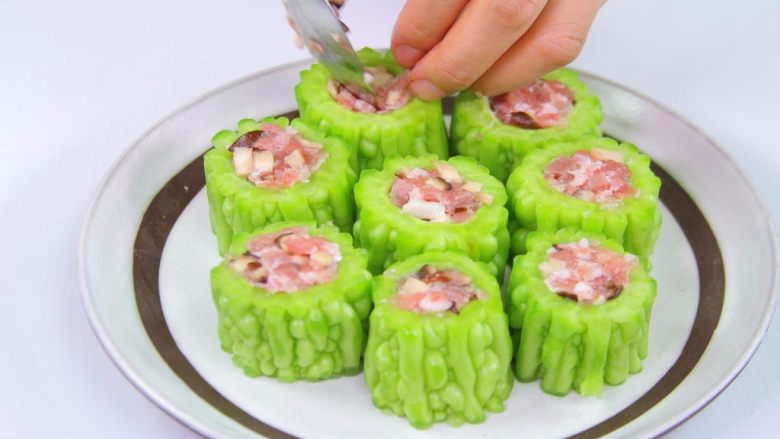 2种苦瓜的吃法 ,将调好的馅料塞入苦瓜内,摆盘,上火隔水蒸8分钟起锅即可。