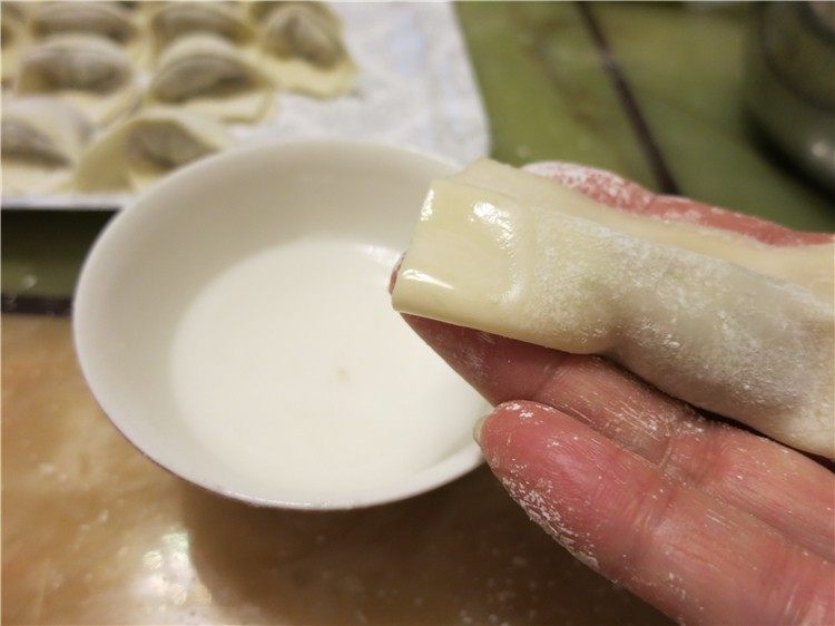 鲜虾鸡汤馄饨,从底边卷起来，在一头沾点水，