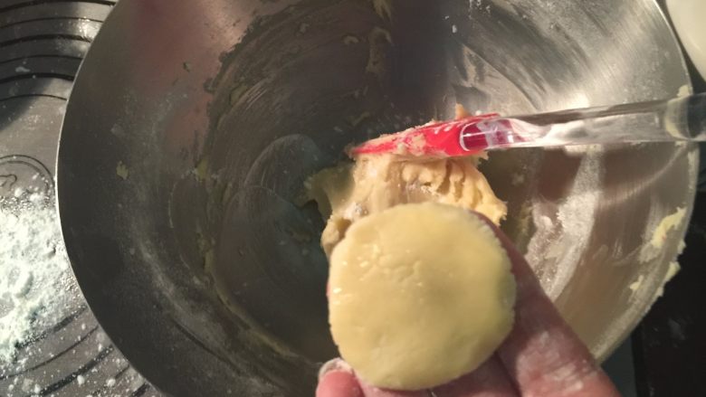 酥皮泡芙,冷藏后,取下10g左右的酥皮面团,在面团上沾一点薄粉,按成一个圆片