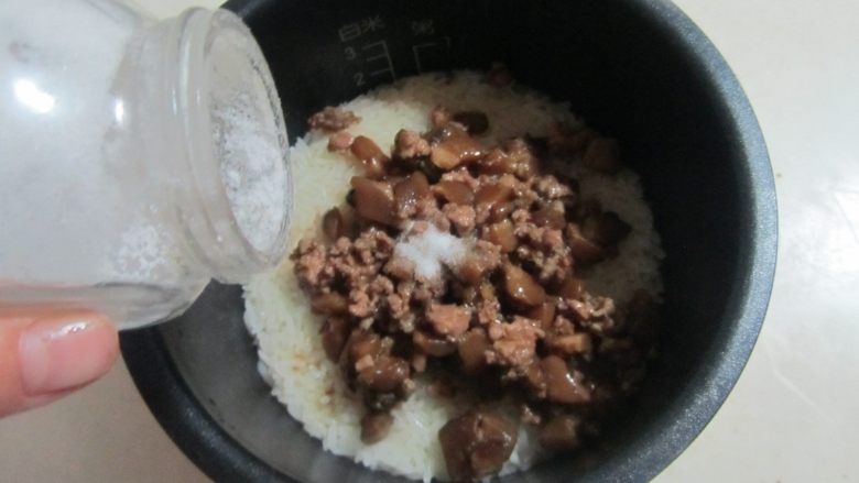 肉末香菇烧麦(饺子皮版),糯米饭煮熟后倒入做好的香菇肉末, 再放入适量的盐和胡椒粉, 拌均匀;
