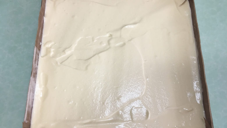 红丝绒旋风蛋糕卷,原味蛋糕糊倒入烤盘中,表面抹平。