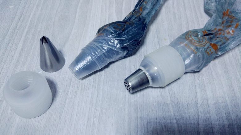 小浣熊立体彩绘杯蛋糕, 将浅灰色,深灰色和白色奶油霜装入不同的裱花袋。一开始我用的蒙布朗裱花嘴,后来发现杯蛋糕太小,花嘴太大,所以重新装入剪小口的裱花袋操作了