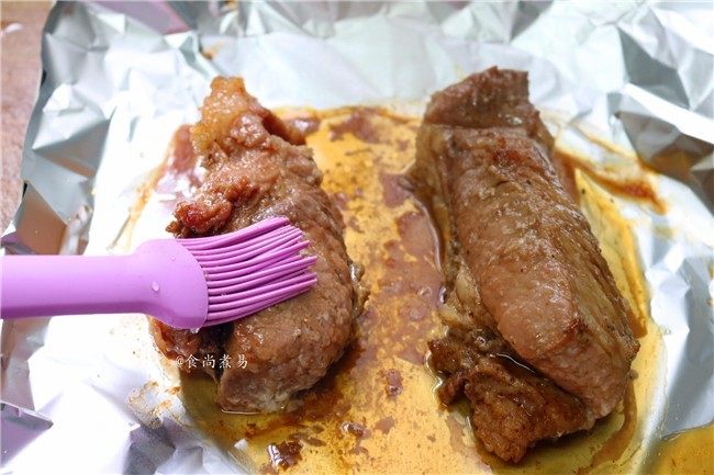私房蜜汁叉烧肉,烘烤时间结束,戴上隔热手套,取出叉烧,刷一两遍蜜糖浆