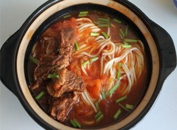 番茄牛腩面,捞出煮好的面条,浇上番茄牛肉汤,放上牛肉,撒少许香草即可。