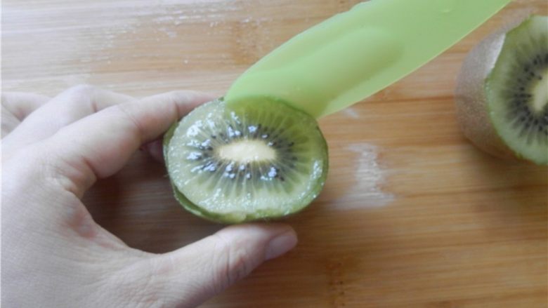 美味的奇异果蜂蜜戚风,用塑料勺子刮一圈果子外皮,去除果皮;