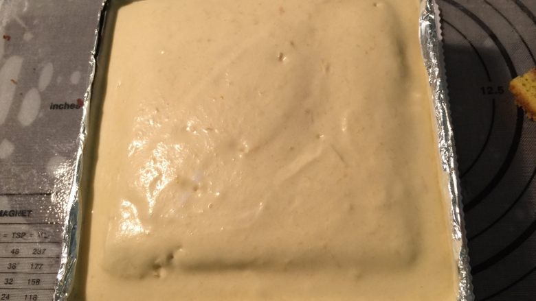 花仙子芒果慕斯,接着倒入适量的芒果慕斯糊,依次把三片蛋糕全部放入后放入冰箱冷藏至表面凝固