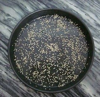 焦糖香蕉花环包,8寸的披萨盘底部抹一层黄油,再撒上适量的白芝麻
