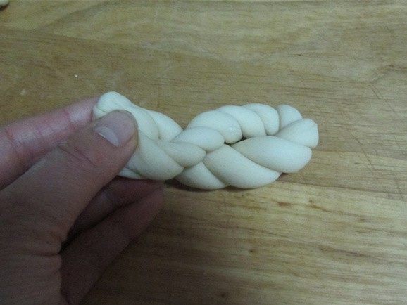 酥脆麻花,再麻花左右手向相反方向揪一下, 再将两端合起, 它们会更拧在一起;