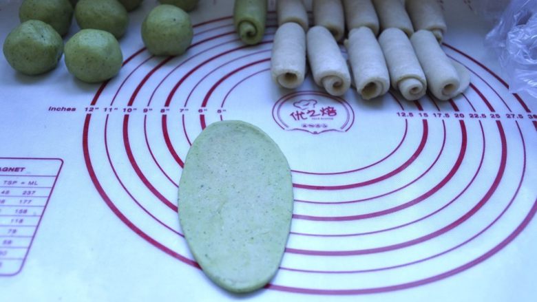 荷花酥,10、在把包好的酥皮2面团也擀开,成牛舌形状,由上往下卷起来,收口朝下,放在面垫上