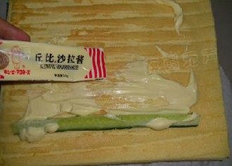 沙拉肉松蛋糕卷,再倒过来,放一条黄瓜,挤上丘比沙拉酱