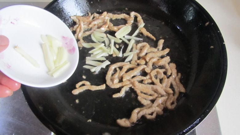 四季豆肉丝炒面,肉丝变色后加入蒜丝进去煸炒;