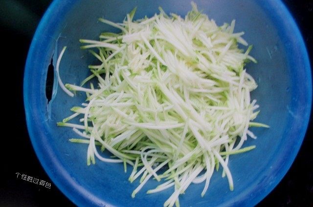 西葫芦糊塌子,西葫芦,洗干净,用刀劈开,里面的子和瓤子,挖出去不要。皮不要擦掉,保留。用擦子,擦成细丝,加小半勺盐,大约3克左右,拌匀,稍微放置一会儿,会