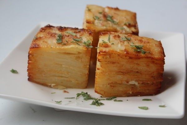 马铃薯千层方块 Potato Pavé,摆盘,洒上一些切碎的<a style='color:red;display:inline-block;' href='/shicai/ 131'>香菜</a>装饰。这马铃薯方块,马铃薯柔软充满乳香,带点胡椒的辣味和煎的香酥的蒜味外层,非常好吃的小品,当前菜或配菜都很合适。