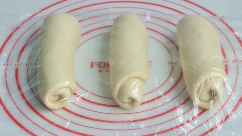 香肠吐司披萨,将面团擀开卷成圆筒状,3个都做同样处理,盖上保鲜膜静置15分钟左右。