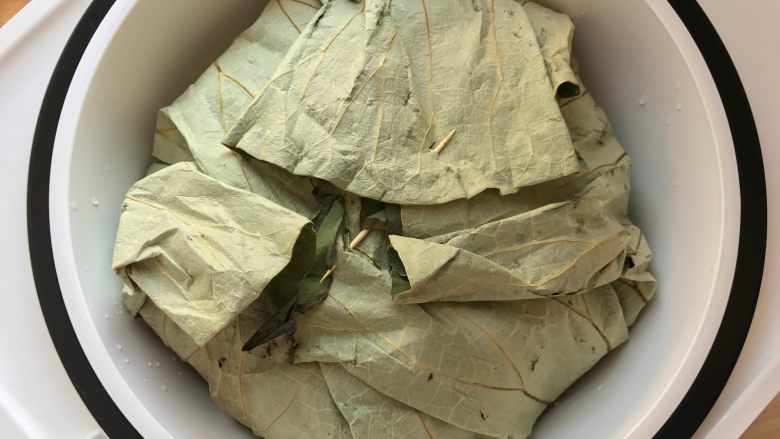 荷香排骨饭,将排骨包裹起来,中间可用牙签固定服帖(注意:荷叶包的高度最好在蒸笼的2/3处),开始烹饪,蒸制1小时即可