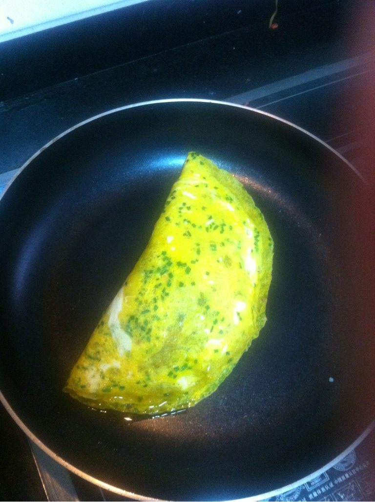 葱香蛋皮包饭,另一半对折过来,用预留的蛋液延边上走一遍,开小火使其封口,口子封上就可以装盘了