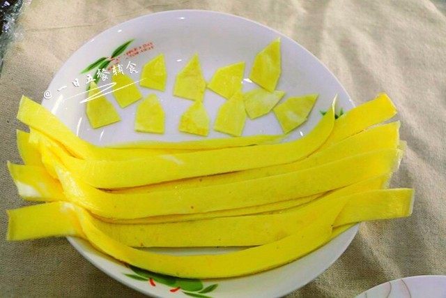 向日葵炒饭, 蛋液倒入锅内,快速转圆。 蛋皮做好,出锅,先把一张蛋皮切成1厘米宽的小条。再把另外一张,先切成小长方形,再把小长方形修成花瓣形状。