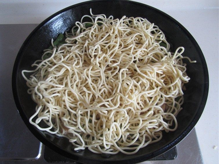 扁豆焖面,将热干面平铺在菜上;