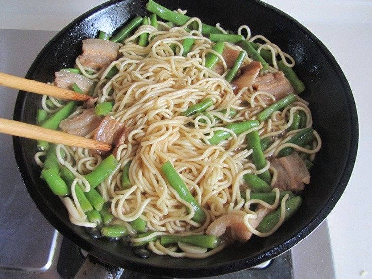 扁豆焖面,关火, 用筷子将它们搅拌均匀,盛入盘中。