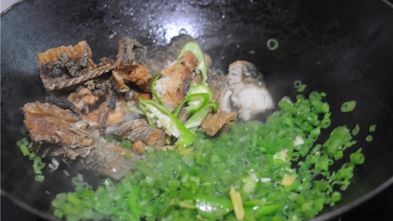 青椒南瓜藤炒干鱼,将南瓜藤扒到一边,倒入干鱼块