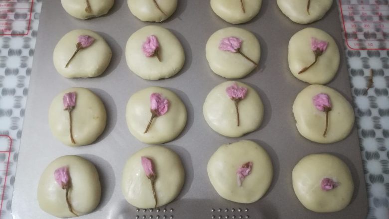 玫瑰鲜花饼,所有的面团依次包好馅料,稍稍按扁,在面团时放上一朵盐渍樱花